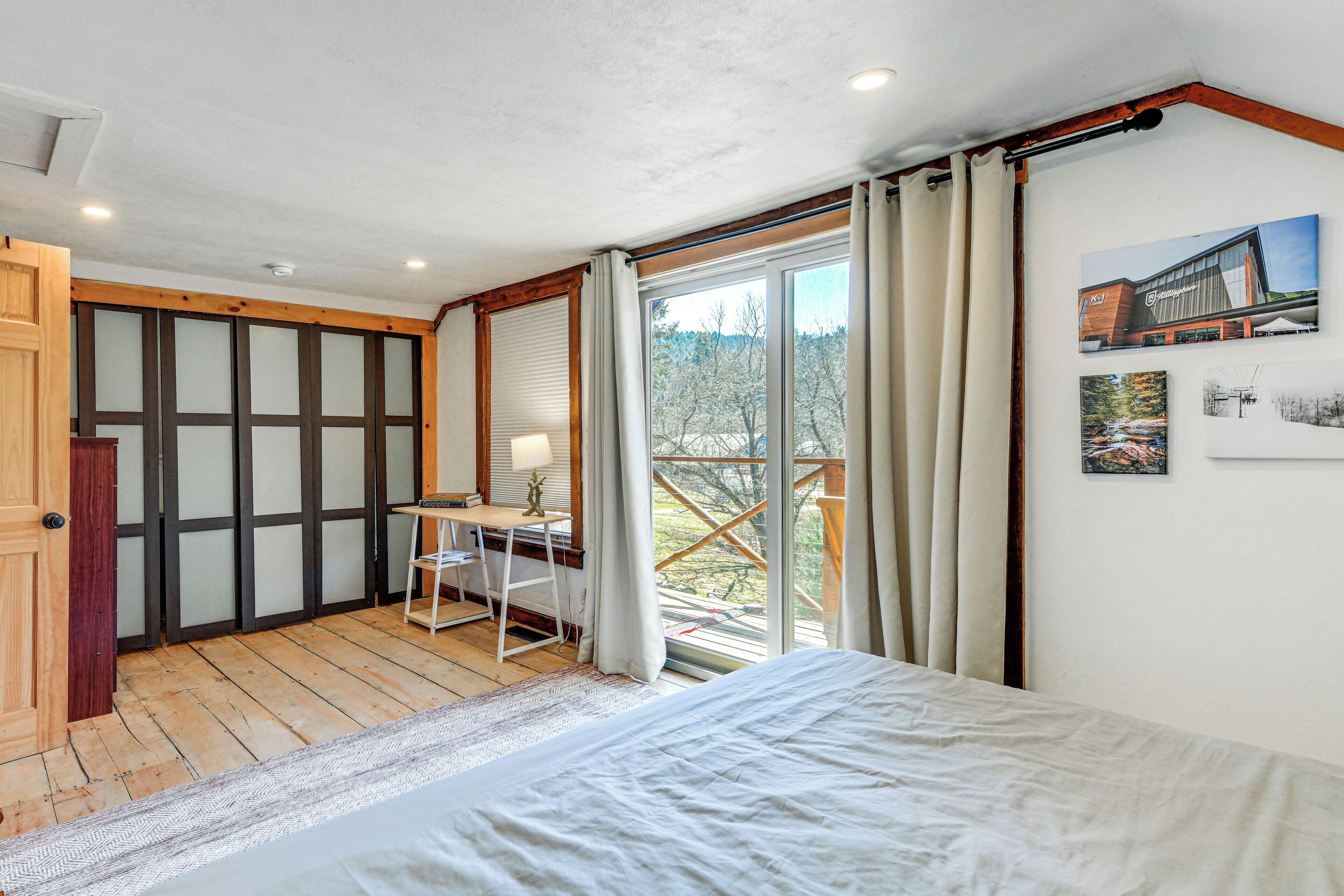 Een slaapkamer met een bed, een bureau en uitzicht op het landschap.