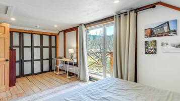 Een slaapkamer met een bed, een bureau en uitzicht op het landschap.