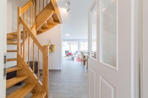 Ein modernes Interieur mit einer Holztreppe, die zu einem Wohnbereich führt.
