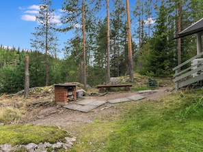 A rustic cabin with a brick structure, a small wooden bench, and a wooden deck. - Lahukka by Interhome (Puumala)