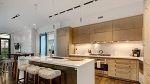 A modern kitchen with a central island, wooden cabinets, stainless steel appliances, and bar stools. - Unbeatable Location, Hot Tub, Luxury Amenities & Year-Round Recreation! Park City Parkite 23 (Park City)