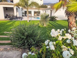 A well-maintained garden with a pool, outdoor seating, and a building with a tiled roof. - Cedelen by Interhome (Plan de la Tour)