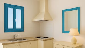 A compact kitchen with two sinks, a stove, and a small table with a lamp. - Sleeps5 - Pool - BySea - Garden - Parking - PetOK (Heraklio)