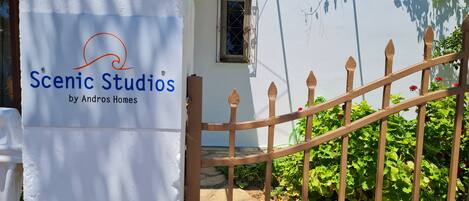 A white building with a sign reading 'Scenic Studios by Andros Homes.'