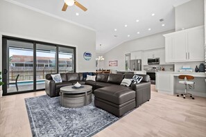 A spacious living area with a large sectional sofa, a coffee table, and a view of a pool through glass doors. - Luxurious retreat on Marco Island  (Marco Island)