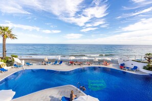 A poolside view with a beach and ocean in the background. - Chalet 'Dominion Beach' with Mountain View, Shared Pools, Terrace, A/C & Wi-Fi (Estepona)