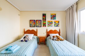 A bedroom with two beds, a nightstand, and wall art. - Chalet 'Dominion Beach' with Mountain View, Shared Pools, Terrace, A/C & Wi-Fi (Estepona)