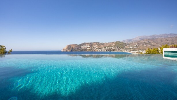 An infinity pool with clear blue water, a view of the sea, and distant mountains. - Villa "Casa San Cayetano" with Sea View, Pool, Garden, Terrace and Balcony (La Herradura)