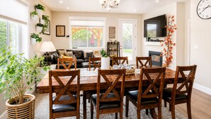 Un coin repas avec une table et des chaises en bois, un téléviseur et une cheminée.