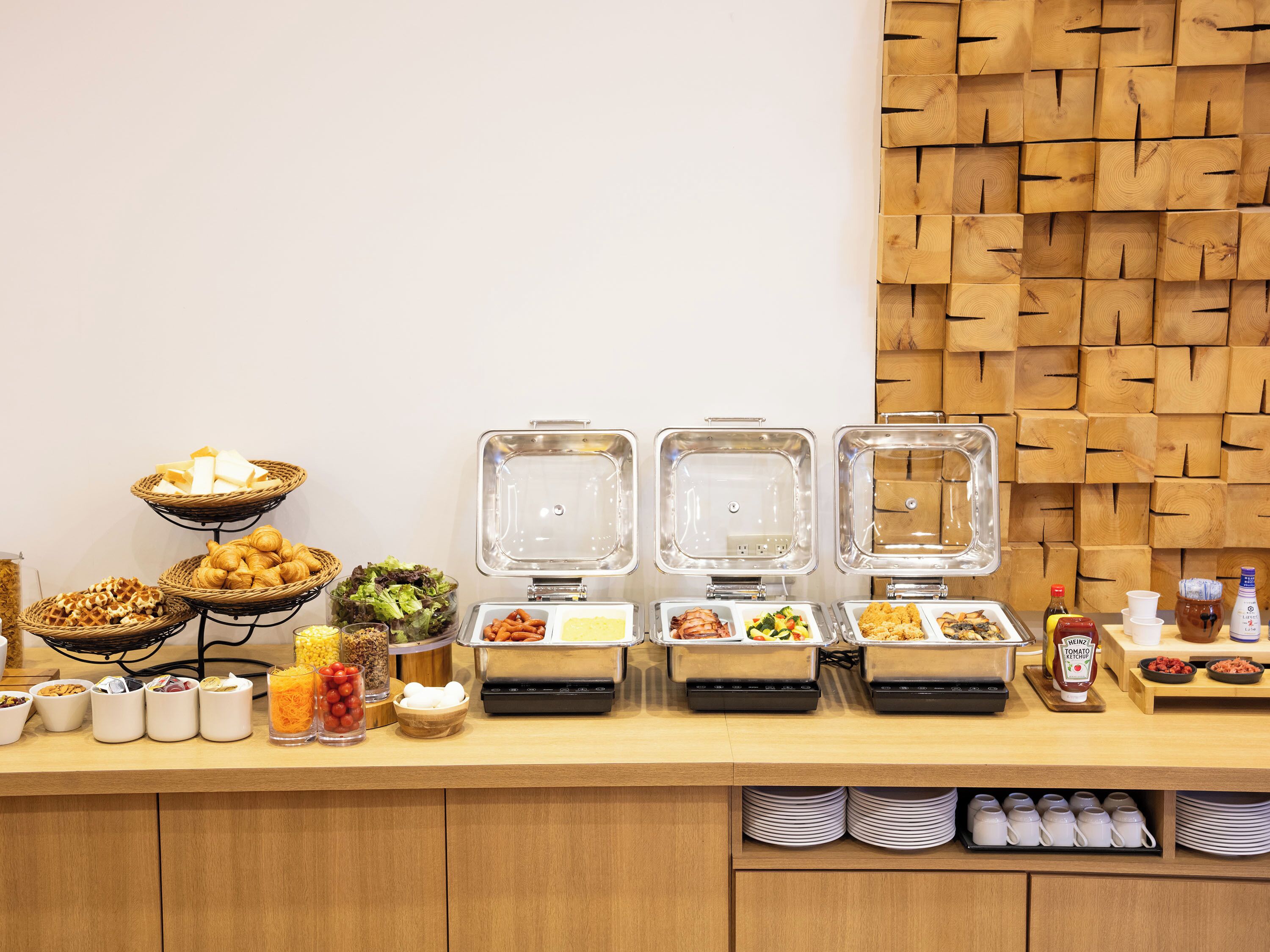 A buffet setup with various food items and condiments.