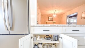 A kitchen with white cabinets, a marble countertop, and a built-in oven. - Home near Calistoga w/ heated pool & hot tub (Santa Rosa)