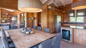 A modern kitchen with wooden cabinets, a large island, and pendant lighting. - Villa Lavezzi by Interhome (Bonifacio)
