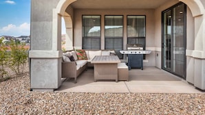 An outdoor patio area with a seating arrangement, a grill, and a view of the surrounding landscape. - The Jungalow by RedAwning (Washington)
