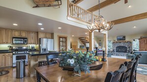 A spacious kitchen with wooden cabinets, a large island, and a dining area with a chandelier. - Beautiful Chamberlands home w/ full access to private Chamberlands pool, beach, and tennis (Tahoma)