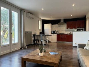 A modern living space with a dining area, kitchen, and seating area.
