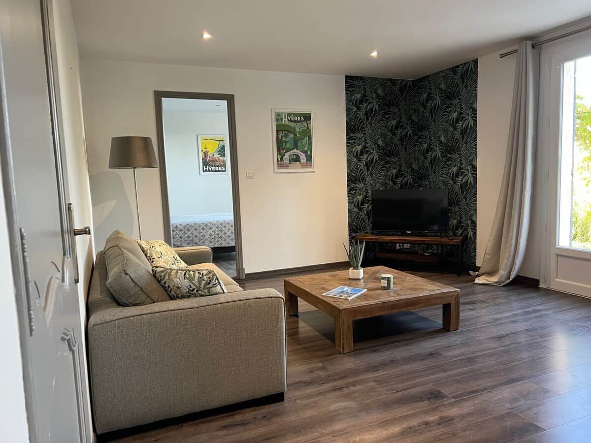 Un salon moderne avec un canapé, une table basse et un téléviseur à écran plat.