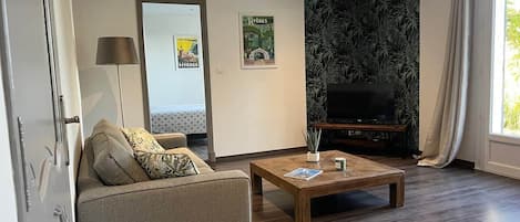Una sala moderna con un sofá, una mesa de centro y un televisor de pantalla plana.