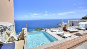 A rooftop pool with a view of the sea, surrounded by lounge chairs and umbrellas. - Villa Flaviana: An elegant and welcoming three-story villa built sheer above the sea, with Free WI-FI. (Praiano)