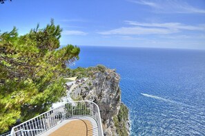 Ein Küstenblick mit einer Treppe, die zu einem Strand führt, mit Blick auf das Meer.