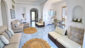 A spacious living area with a sofa set, a dining table, and a kitchen in the background. - Villa Flaviana: An elegant and welcoming three-story villa built sheer above the sea, with Free WI-FI. (Praiano)