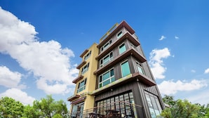 A multi-story building with a modern architectural design, featuring balconies and large windows. - Hi Yeongjin Spa Pension (Gangneung)