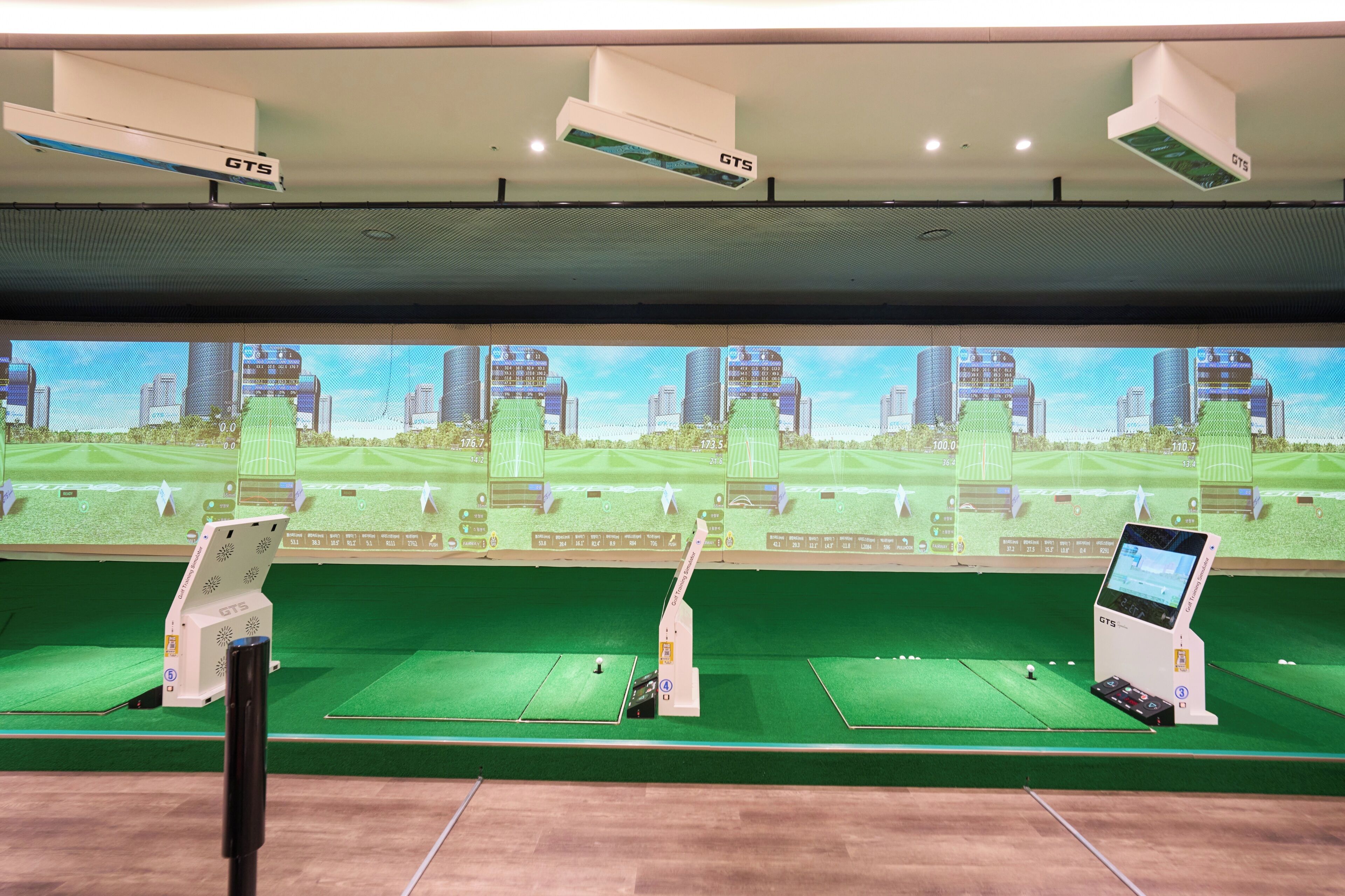 Configuración de simulación de golf con varias pantallas, un panel de control y un sistema de destino.