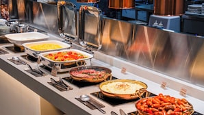 Un bufé con diversos platos de comida y utensilios para servir.