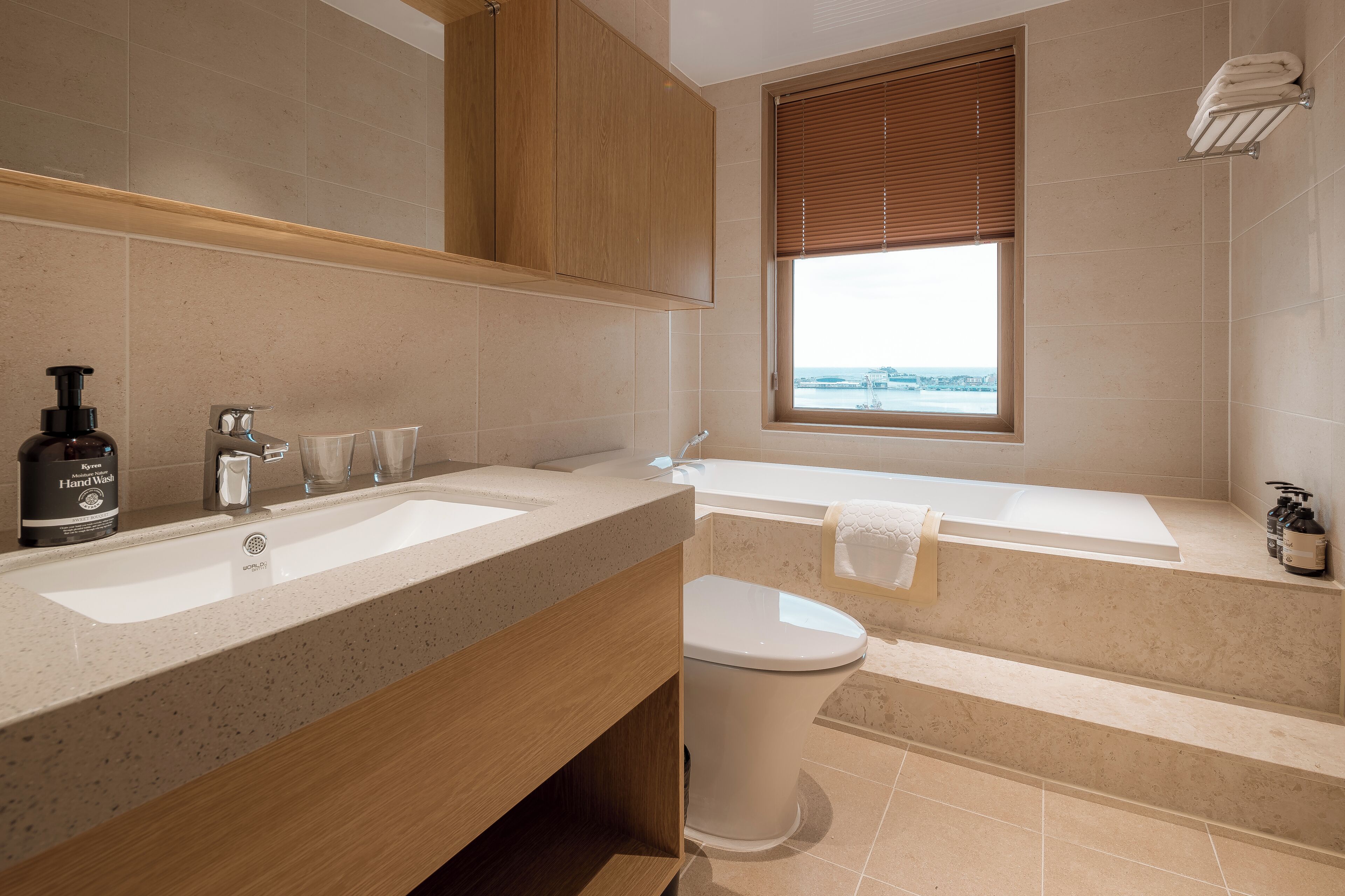 Une salle de bain moderne avec un double vasque, des toilettes et une baignoire.