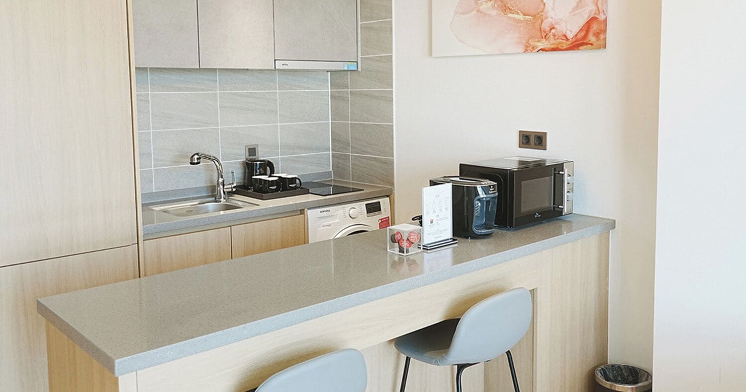 A modern kitchen with a bar area, a dishwasher, a microwave, and a coffee maker.