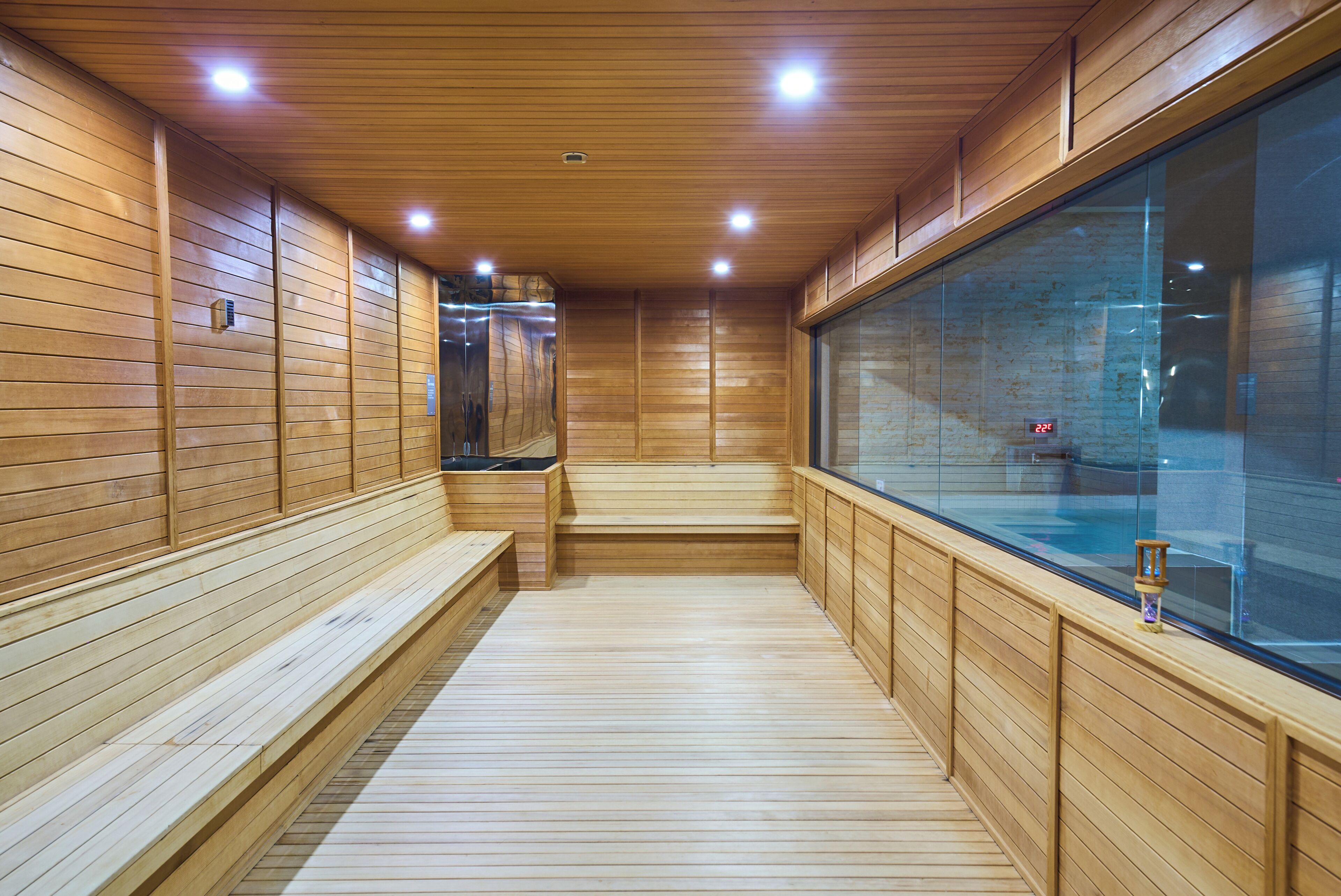 Un intérieur en bois avec des bancs et un mur en verre.