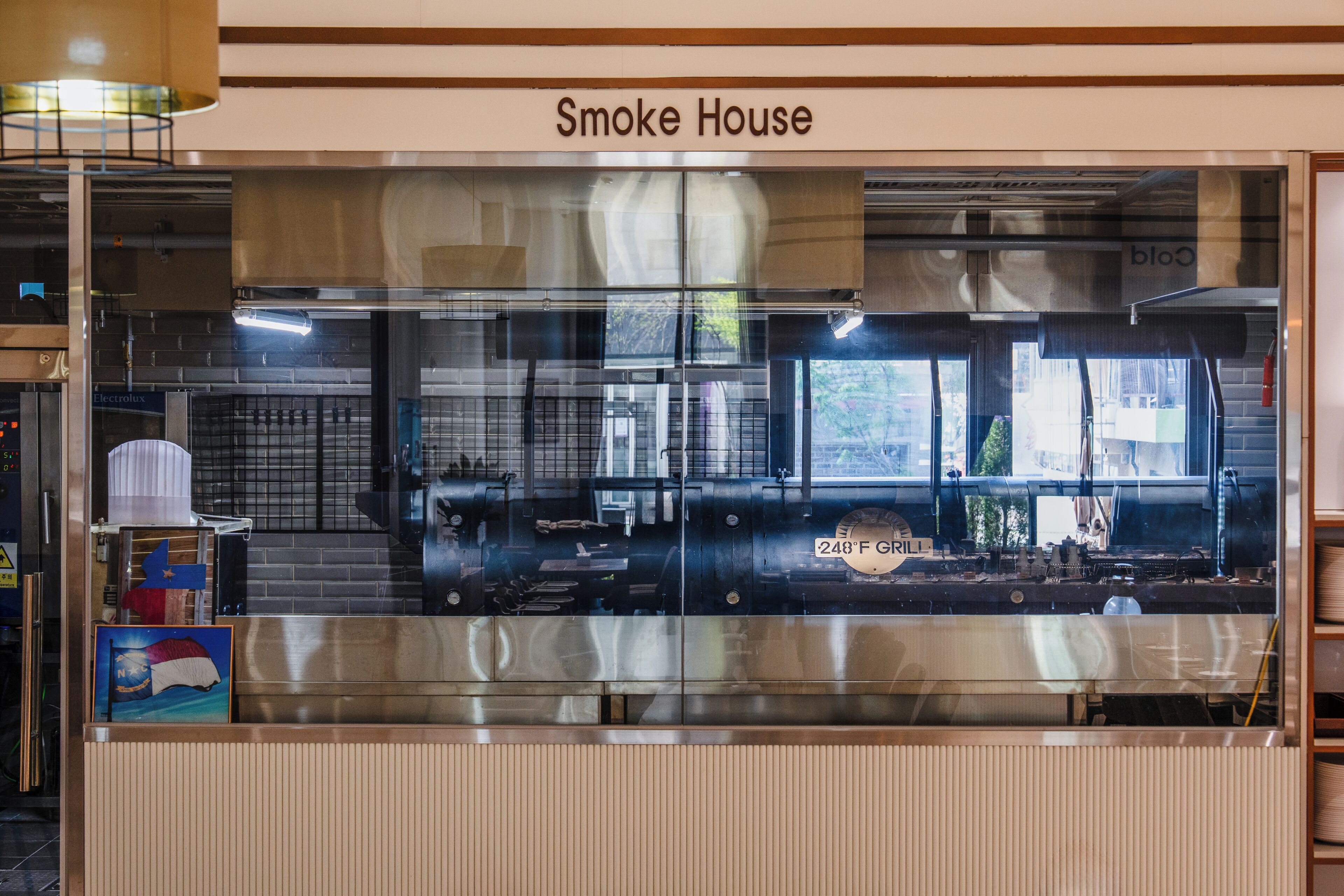 A restaurant named Smoke House with a glass enclosure, industrial kitchen equipment, and a visible temperature control of 248°F.