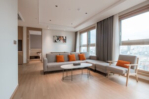 Una sala de estar moderna con un sofá, sillones y una mesa de centro.