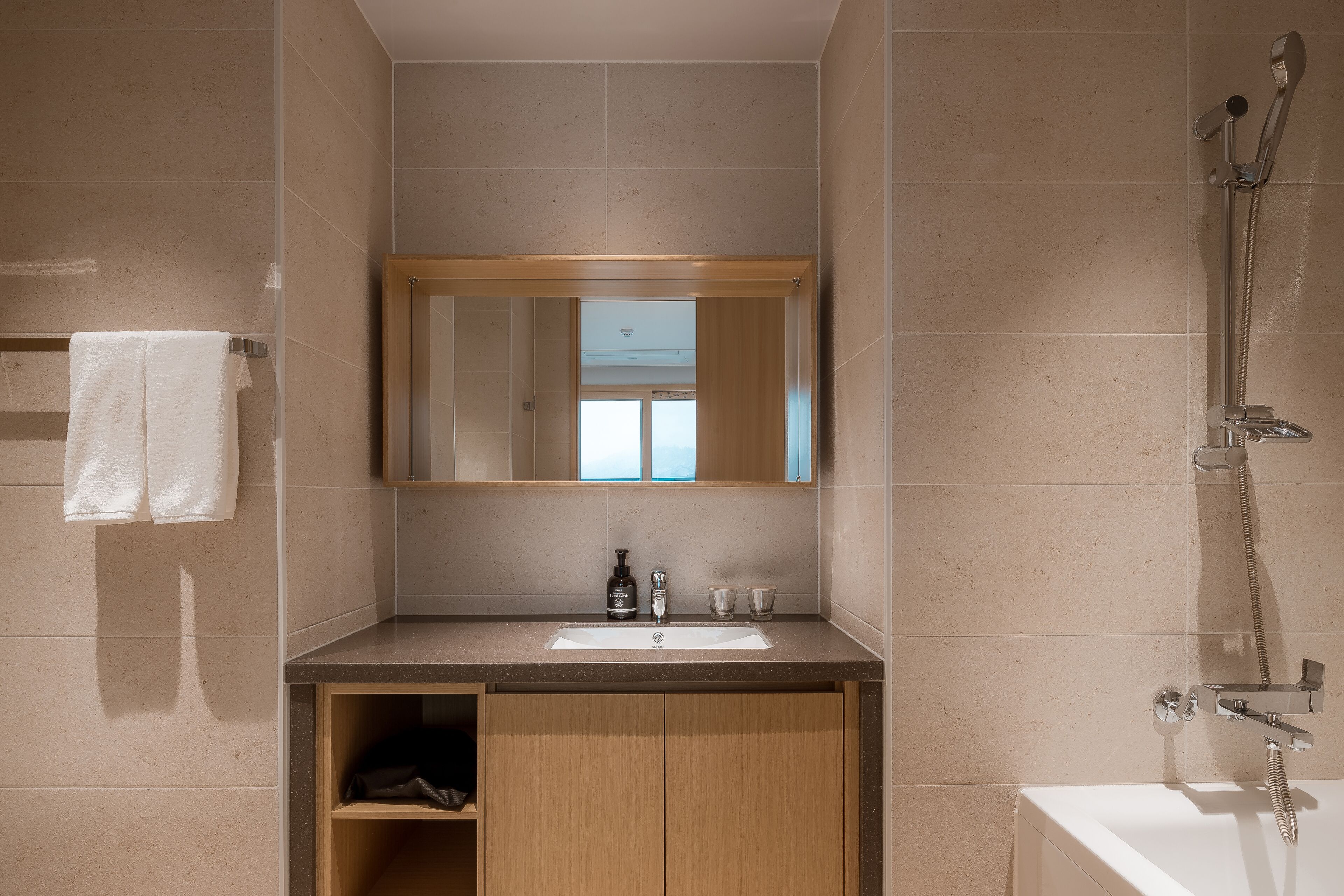 Une salle de bain moderne avec un lavabo, un miroir et une douche.