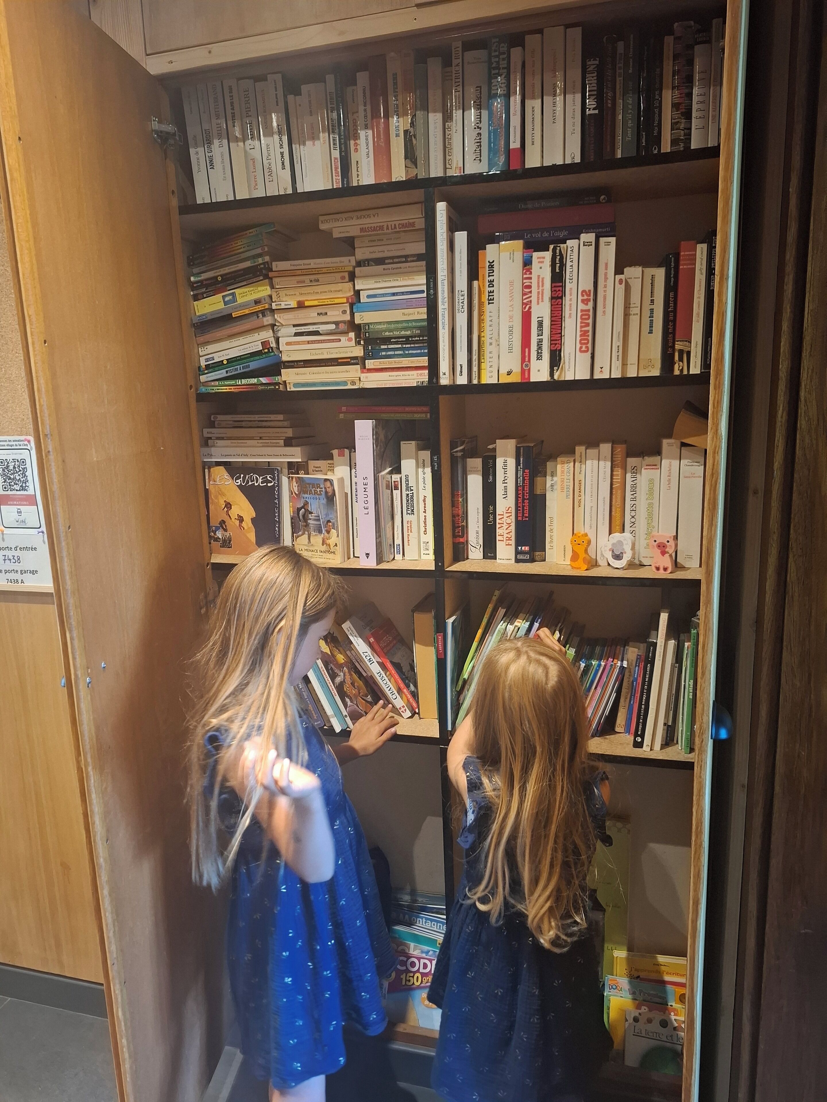 A bookshelf filled with books and a QR code on the wall.