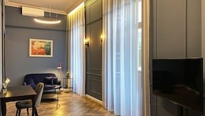 Un salon moderne avec un canapé, une table à manger et un téléviseur.