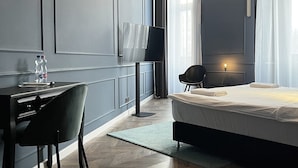 Une chambre à coucher moderne avec un lit, un bureau, une chaise, une télévision et une lampe.