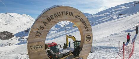 Ein Holzschild mit dem Text 'It's a beautiful journey' und 'Nokian Tyres' vor einem verschneiten Berg.