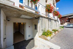 A hotel entrance with a door marked 'Privato,' a concrete wall, and a car parked outside. - Casa Silvia Ski In (Livigno)