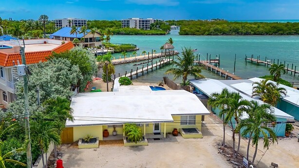 A coastal hotel with a large open patio, a dock, and a view of the sea. - 5 Seas Retreat 4 bed 2 bath dock, pool, Sandy Beach Dockage For up to a 25 ft boat (Marathon)