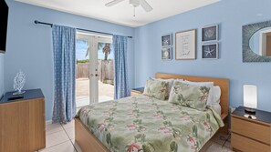 A bedroom with a bed, a nightstand, a dresser, a ceiling fan, and a view through a door. - 5 Seas Retreat 4 bed 2 bath dock, pool, Sandy Beach Dockage For up to a 25 ft boat (Marathon)