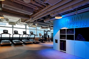 A gym with treadmills, a wall-mounted exercise machine, and a wall with the text 'EVERY DAY MUGZLIN'. - The Arca (Hong Kong Island)
