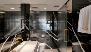 A modern bathroom with a large mirror, a sink, and a towel rack.