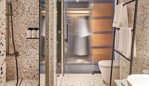 Ein Badezimmer mit Dusche, Toilette und Handtuchhalter.