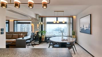 A modern office space with a round table, leather sofa, and potted plants.