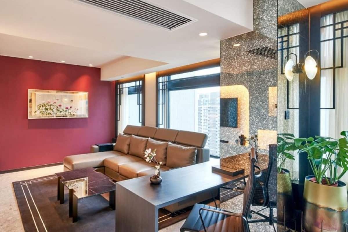 A modern living room with a sofa, coffee table, and potted plants.
