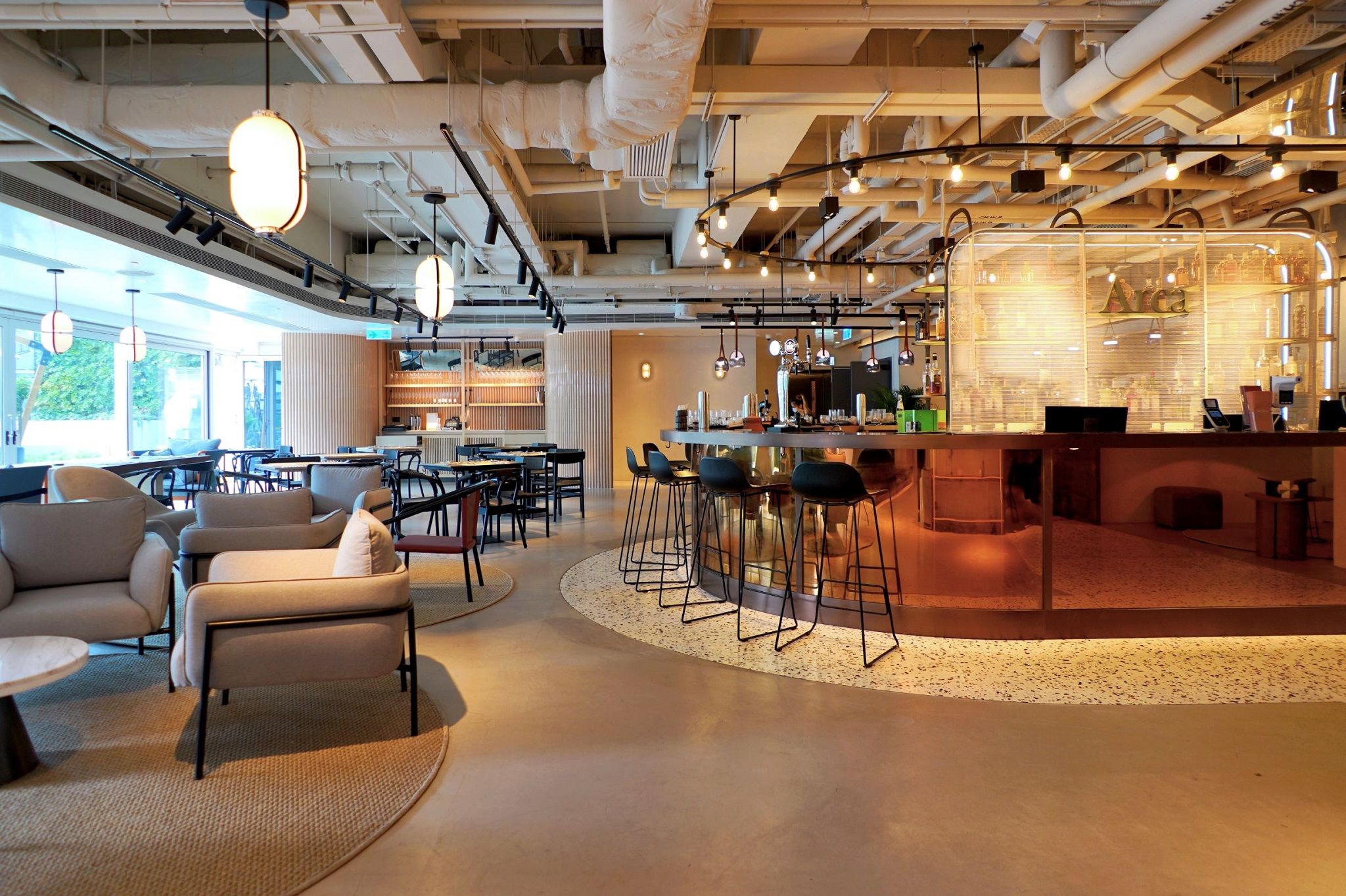 A modern interior with a bar area, seating, and a visible kitchen.