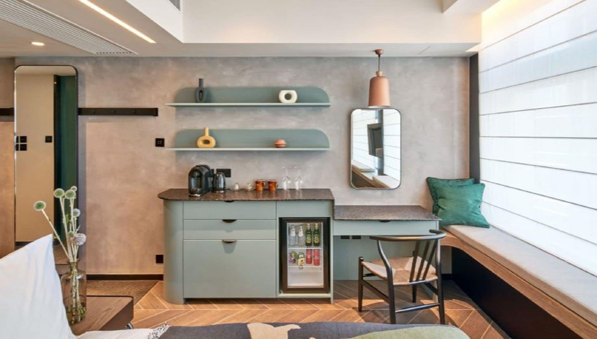 A compact kitchenette with a built-in fridge, a small bar area, and a seating bench.