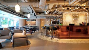 Decoração moderna com área de bar, assentos e cozinha à vista.