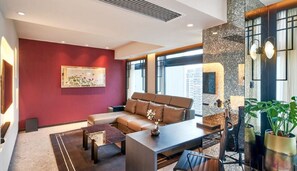 A modern living room with a sofa, coffee table, and potted plants.