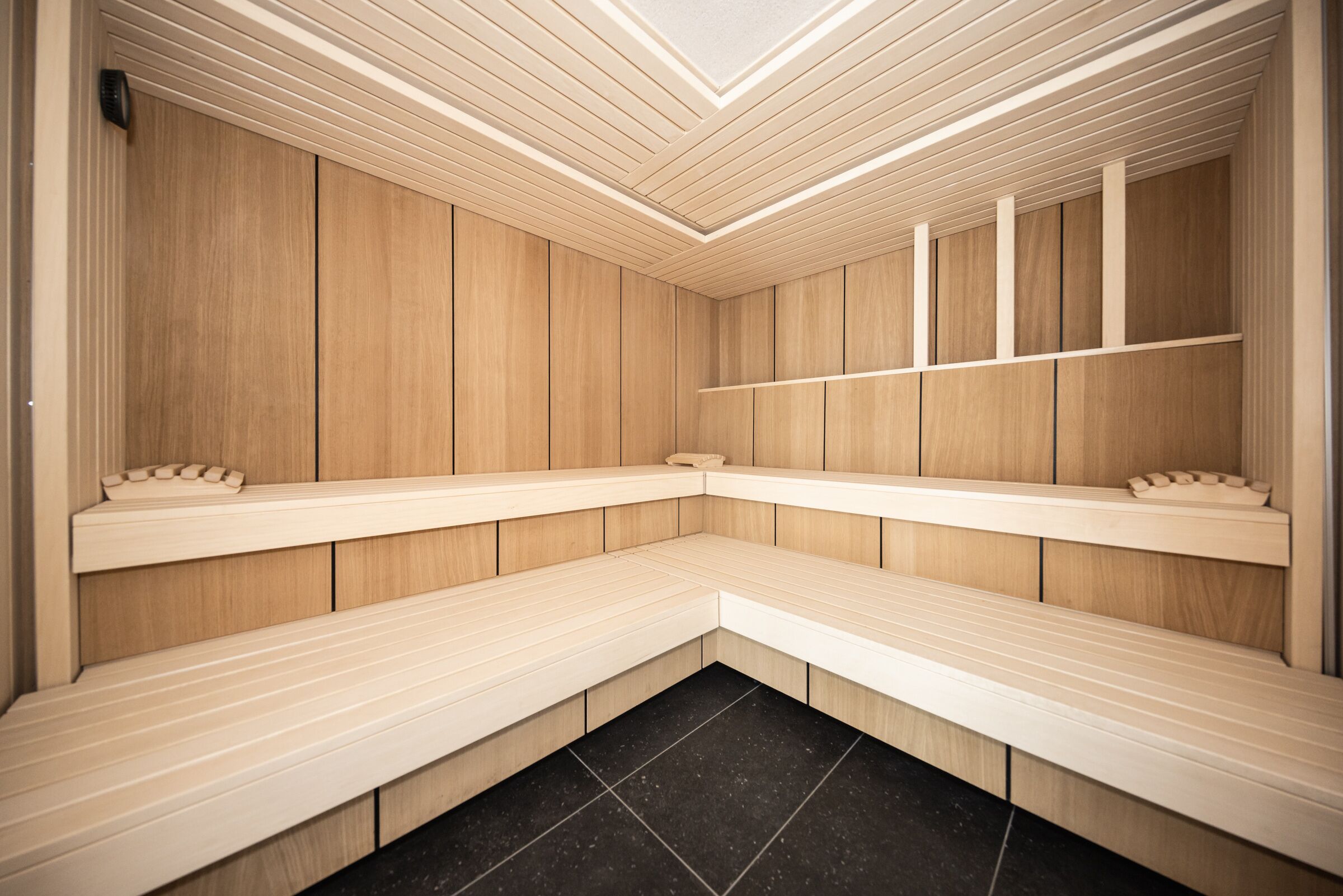 A sauna with wooden benches and a tiled floor.
